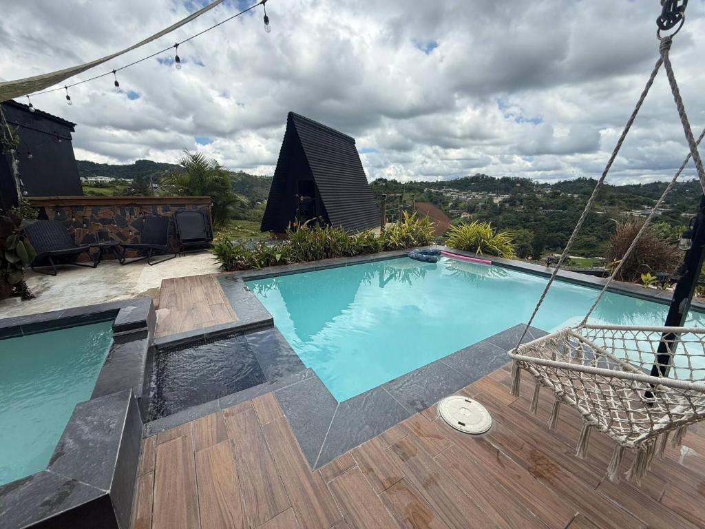 a swing over a swimming pool on a house at Vibra Barranquitashot pool in Barrancas