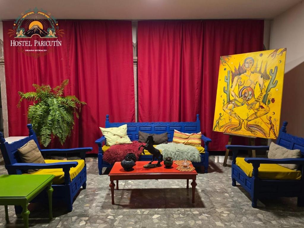 a living room with blue couches and a table at Hostel Paricutín in Uruapan del Progreso