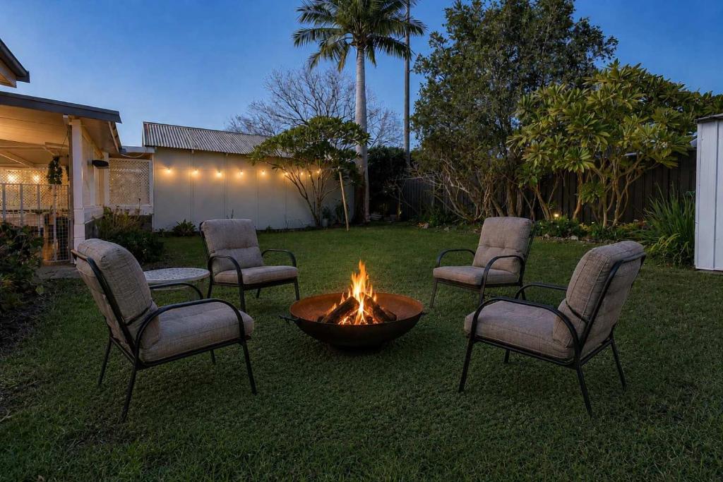 a group of chairs around a fire pit in a yard at Morpeth Cottage in Morpeth
