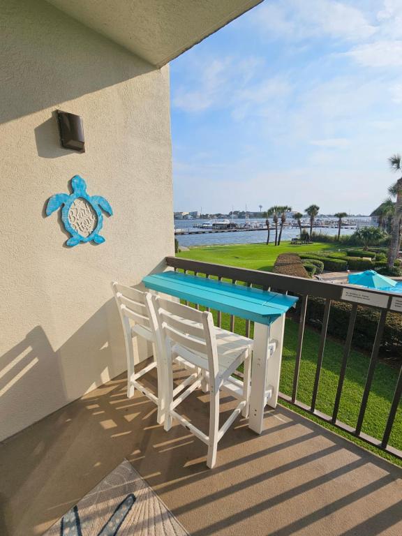 a table and chairs on a balcony with a view of the ocean at Salty Love Nest in Fort Walton Beach