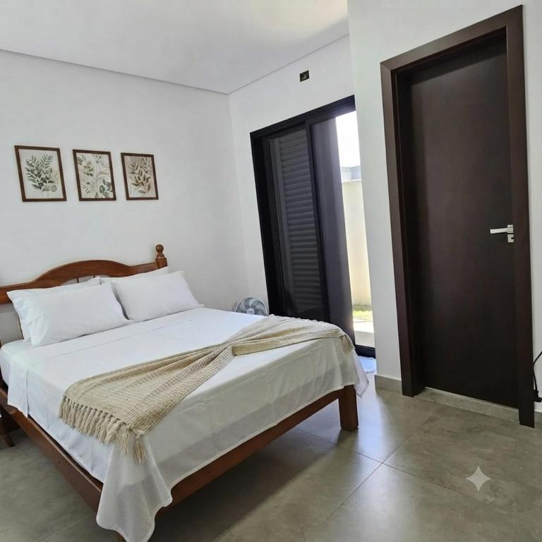 a bedroom with a bed and a black door at Suítes Ninho dos Lobos in Pardinho