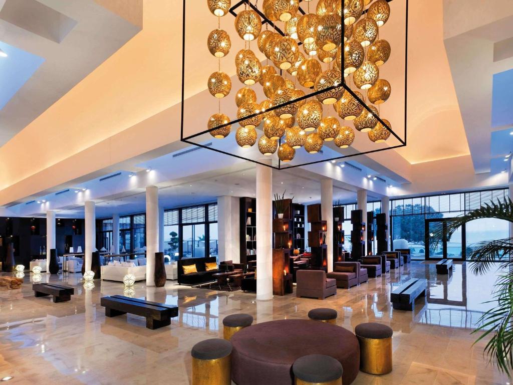 a large lobby with a large chandelier in a building at Mövenpick Hotel Gammarth Tunis in Gammarth