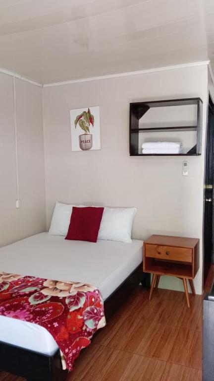 a bedroom with a large bed and a night stand at Apartamentos Caimán 3 in Tortuguero