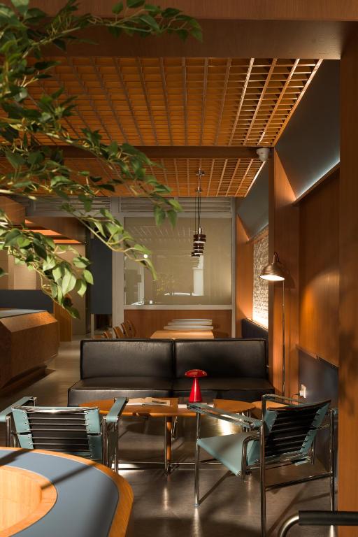 a lobby with a couch and tables and chairs at Aura Hotel Purvis in Singapore