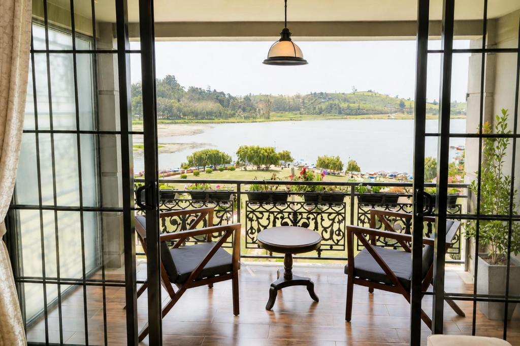 a balcony with a view of a lake at Royal Lake Hotel in Nuwara Eliya
