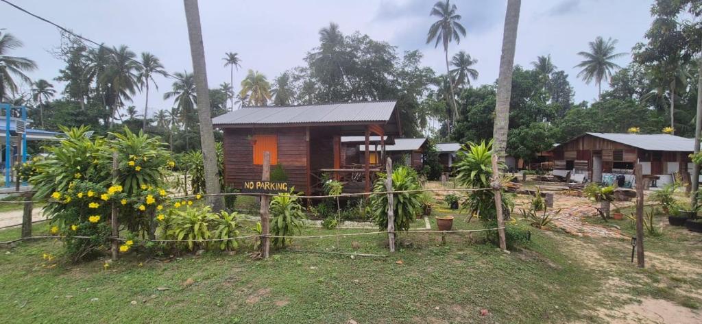 a small house in a garden with palm trees at The Nest in Cherating