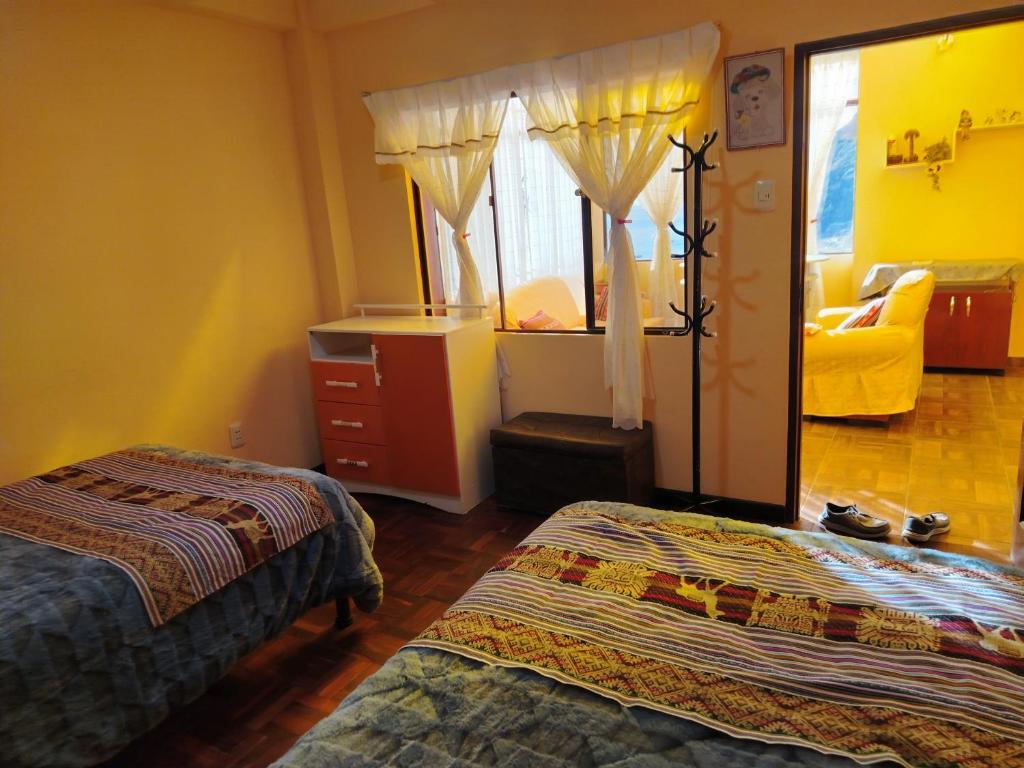 a bedroom with two beds and a chair and a window at Leo in Copacabana