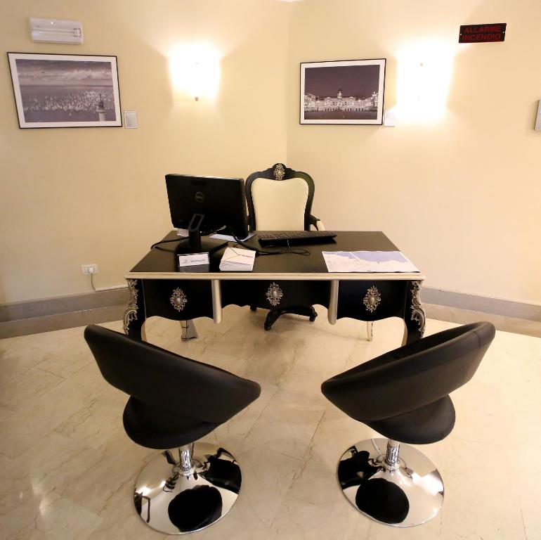 an office with a desk with a computer and two chairs at Hotel San Rocco in Muggia