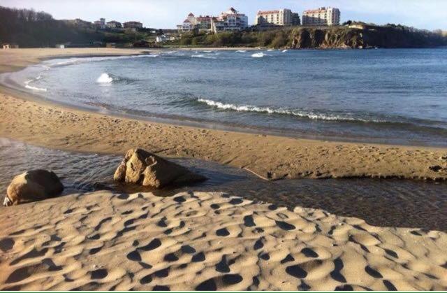 a beach with two rocks in the sand and water at Apart Hotel Apolonia Palace in Sinemorets