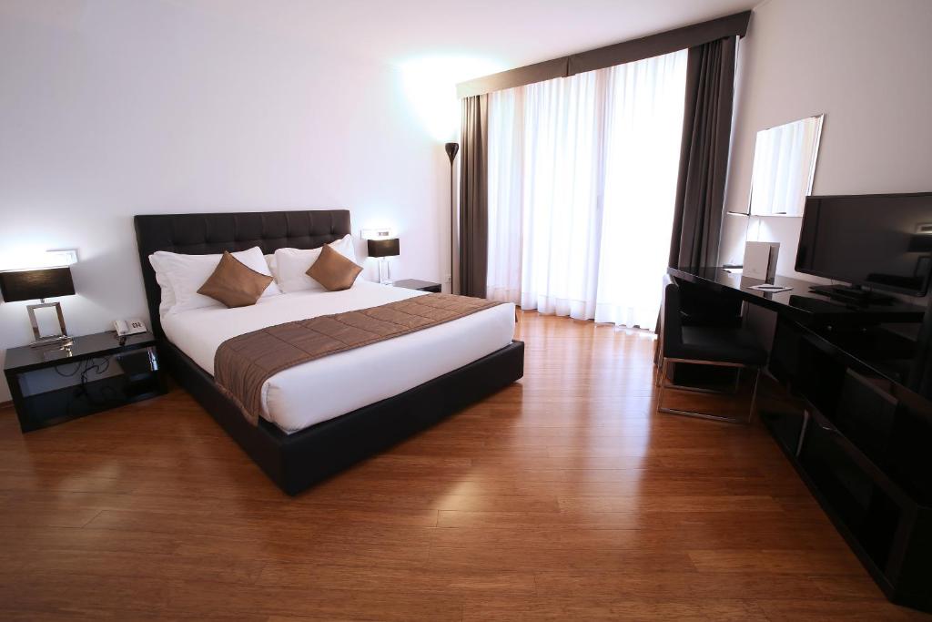 a hotel room with a bed and a television at Hotel San Rocco in Muggia