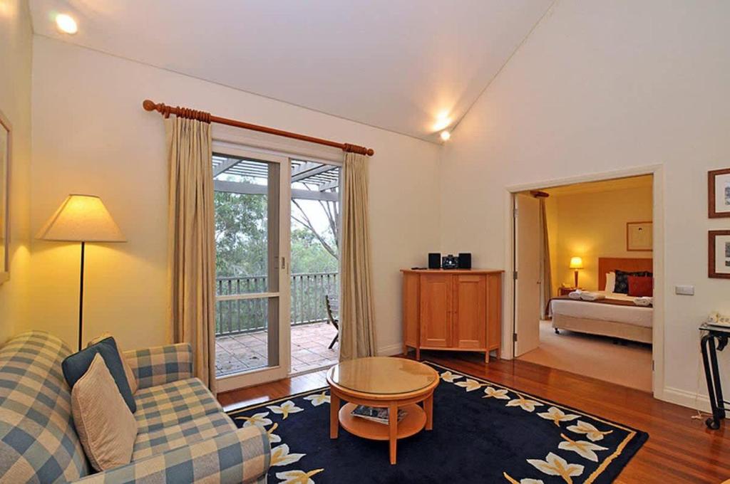 a living room with a couch and a table at Villa 1br Merlot Villa located within Cypress Lakes Resort in Pokolbin