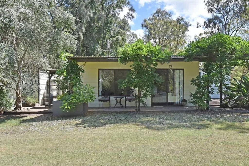a yellow house with a patio and trees at Olive Grove 1 Studio in Pokolbin