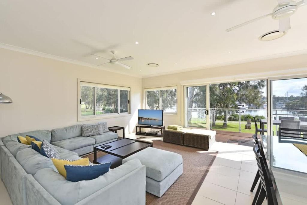 a living room with a couch and a table at Wangi Lakehouse in Wangi Wangi