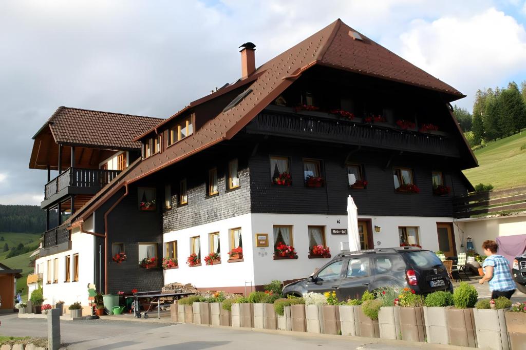 a black and white house with a car parked in front at Ferienwohnung Bergerhöh in Todtnauberg
