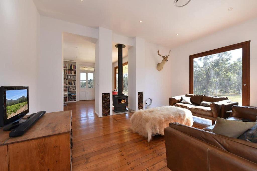 a large living room with a couch and a fireplace at The Parsons Retreat in Rothbury