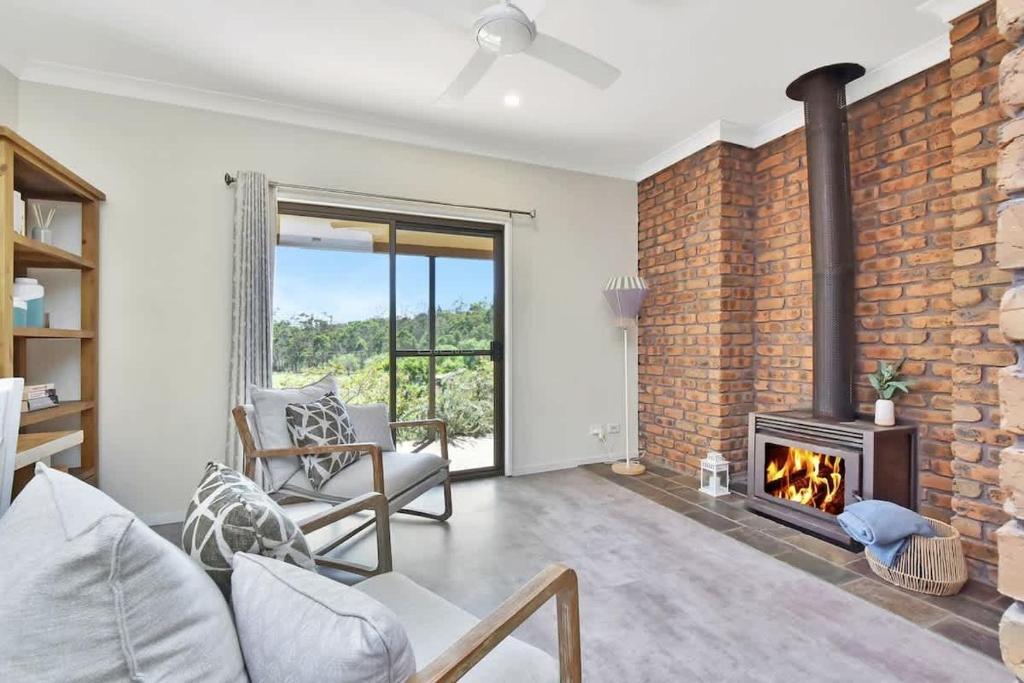 a living room with a brick wall and a fireplace at Kookaburra Range in Greta