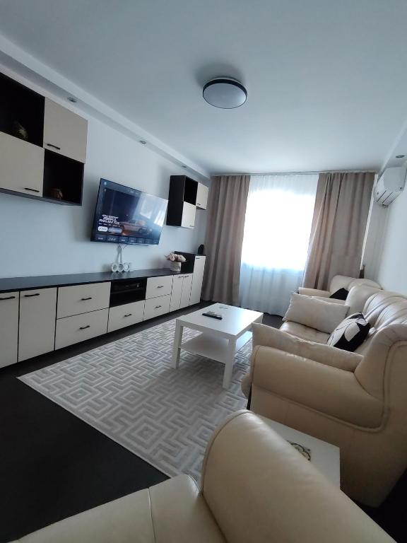 a living room with a couch and a tv at Adrian Home City in Ploieşti