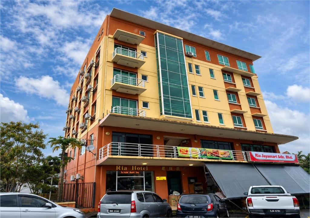 a tall building with cars parked in front of it at Kudat Ria Hotel Plt in Kudat