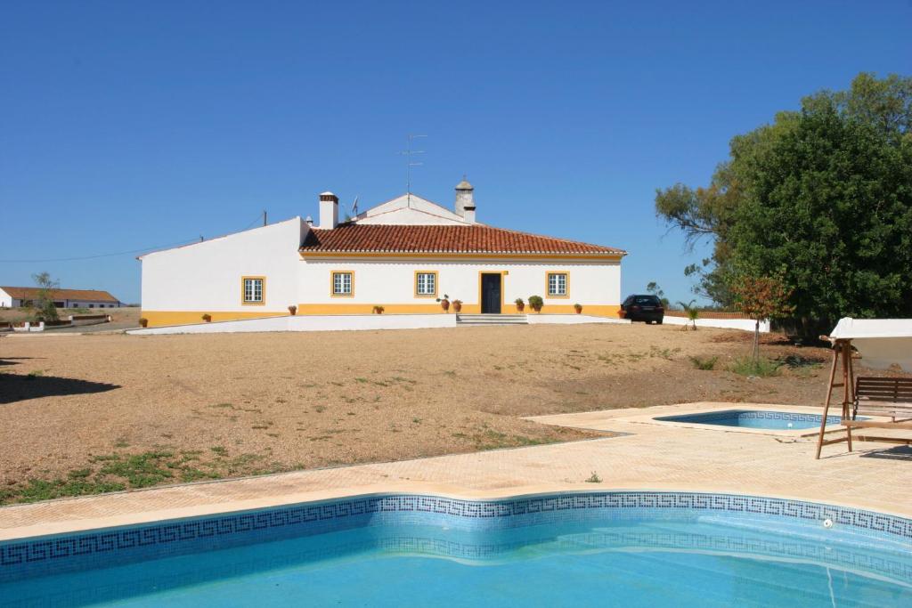 une maison et une piscine en face d'une maison dans l'établissement Monte da Corte Ligeira, à Cabeça Gorda