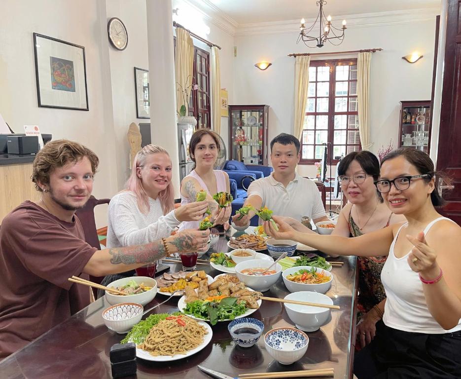 a group of people sitting around a table eating food at Tuna Homestay Hanoi & Experience in Hanoi