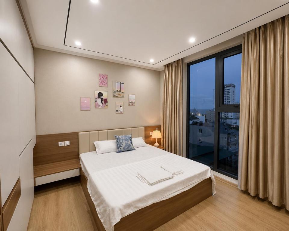 a bedroom with a bed and a large window at Beer's Homes Căn hộ chung cư Pearl Residence in Cửa Lô