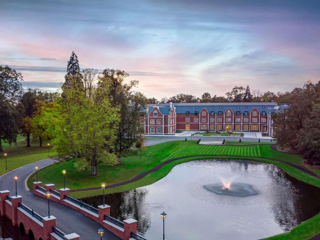 a building with a pond in front of it at Fairmont Windsor Park in Windsor