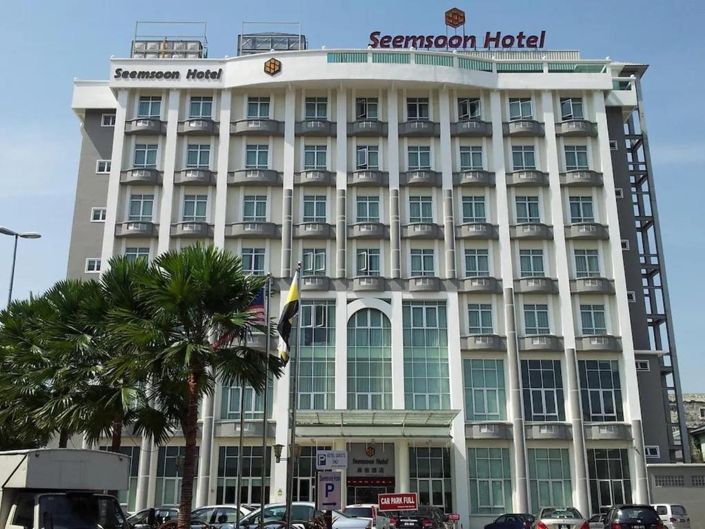 ein großes weißes Hotel mit einer Palme davor in der Unterkunft Sunday Near Gerbang Malam Ipoh Formerly Seemsoon in Ipoh