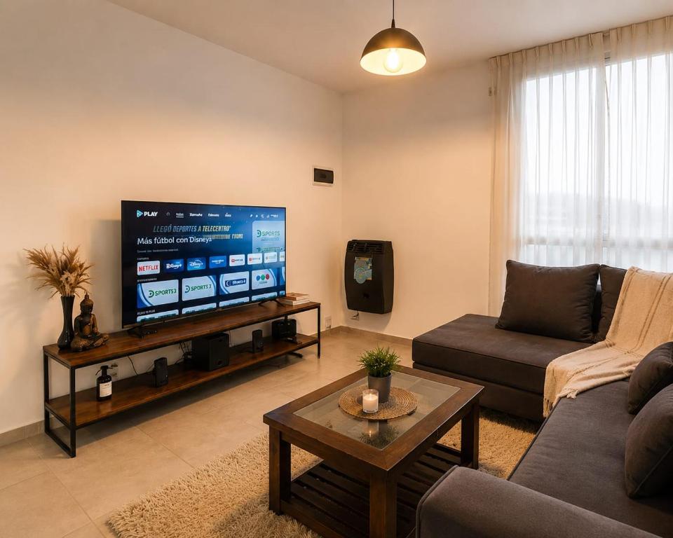 a living room with a couch and a flat screen tv at Bohemian dream in Ezeiza