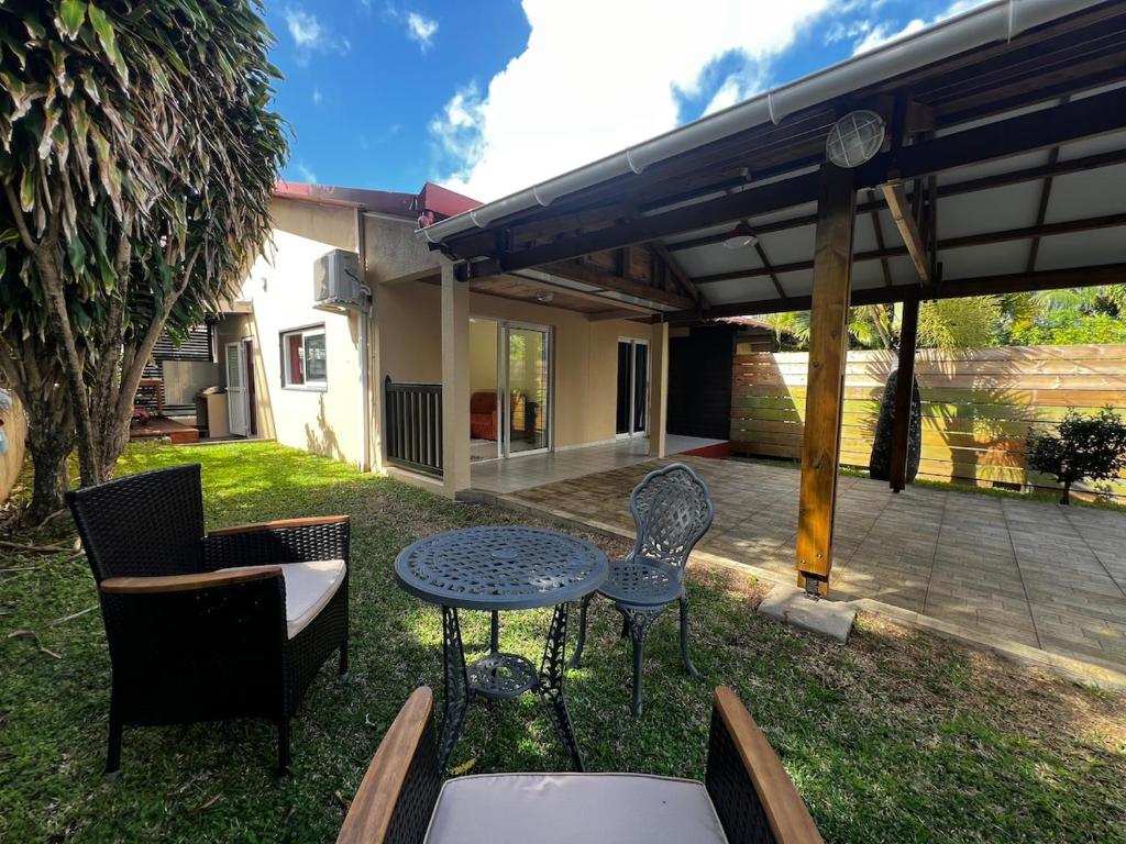 a patio with a table and chairs in the yard at La Caze Vital in Saint-Joseph