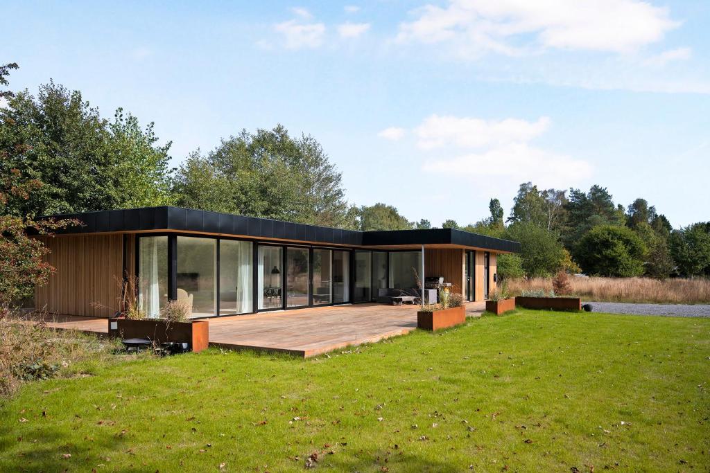 a modular house with a large deck on a lawn at Holiday Home On Bornholm Close To Sea And Beach in Vester Sømarken