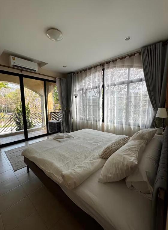 a bedroom with a large bed with a large window at Clock Tower Apartments Chroma Pulse in Pai