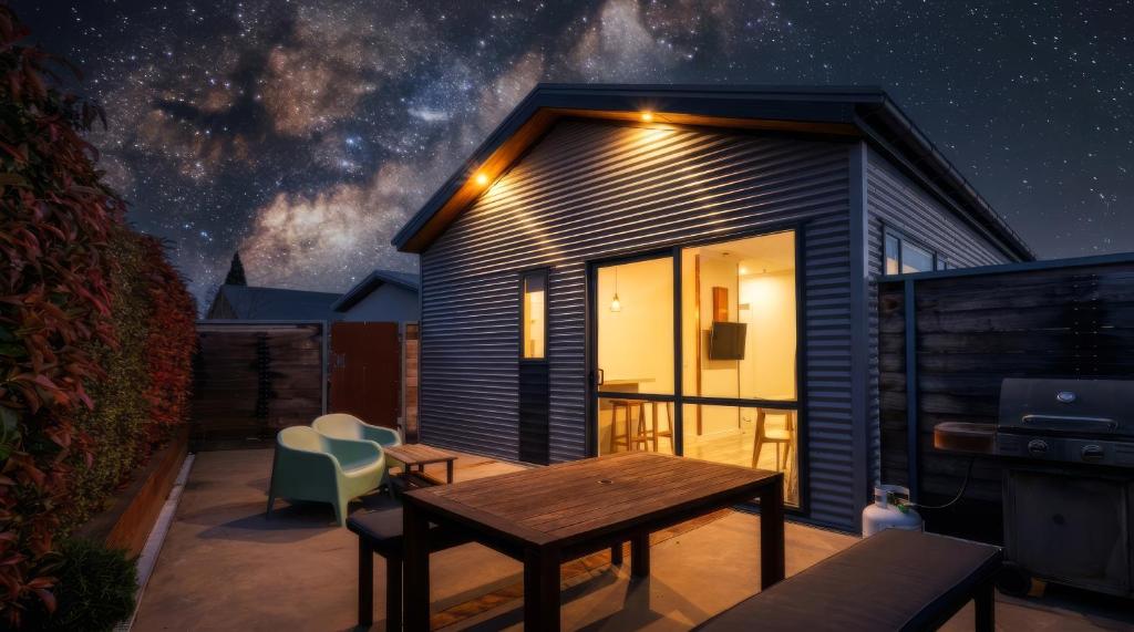 a small house with a table and chairs on a patio at Twizel Cottages in Twizel