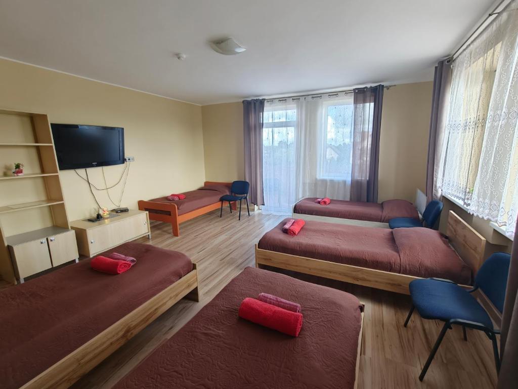 a room with three beds with red pillows at Babilonas in Plungė