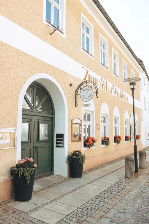 a building with a green door on a street at Aparthotel Alter Weißbräu in Bad Birnbach