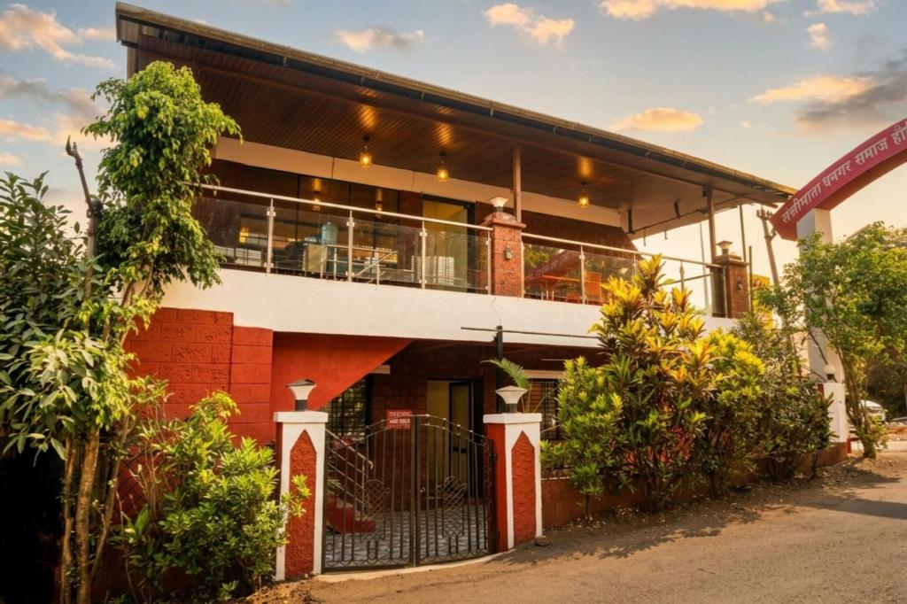 a red brick building with a balcony on it at Green Woods Cottage by JN in Mahabaleshwar
