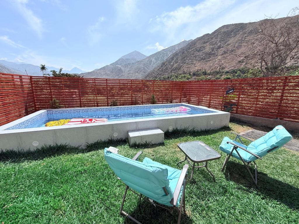 a yard with two chairs and a swimming pool at Villa Doña Isabel in Lunahuaná