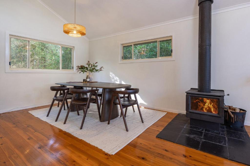 a living room with a table and a fireplace at Sunset Palms in Smiths Lake