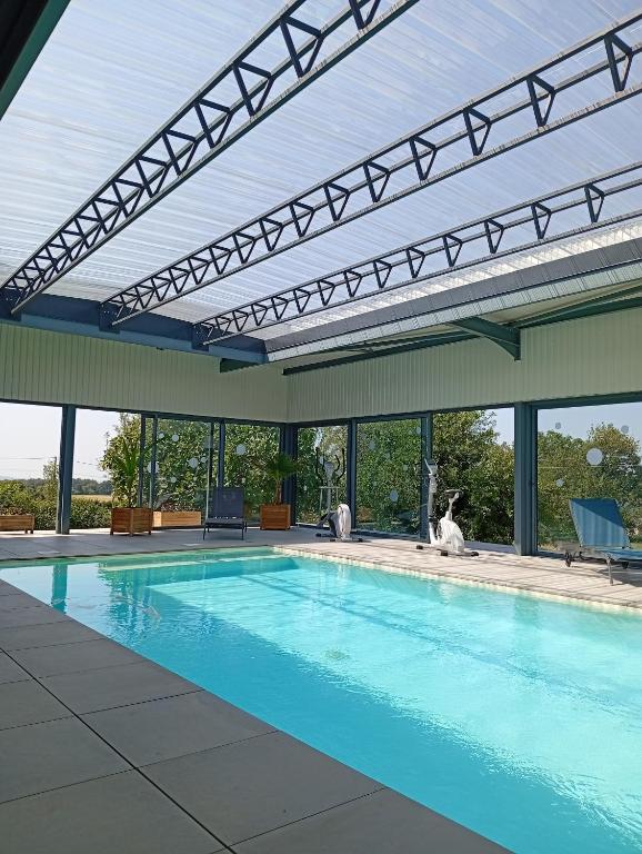 a swimming pool with awning over it with a swimming pool at Le Coquelicot in Najac