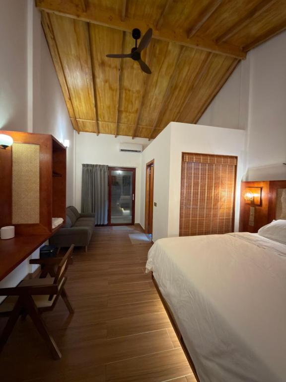 a bedroom with a bed and a ceiling fan at HB'S iSLAND LiFE in Mathiveri