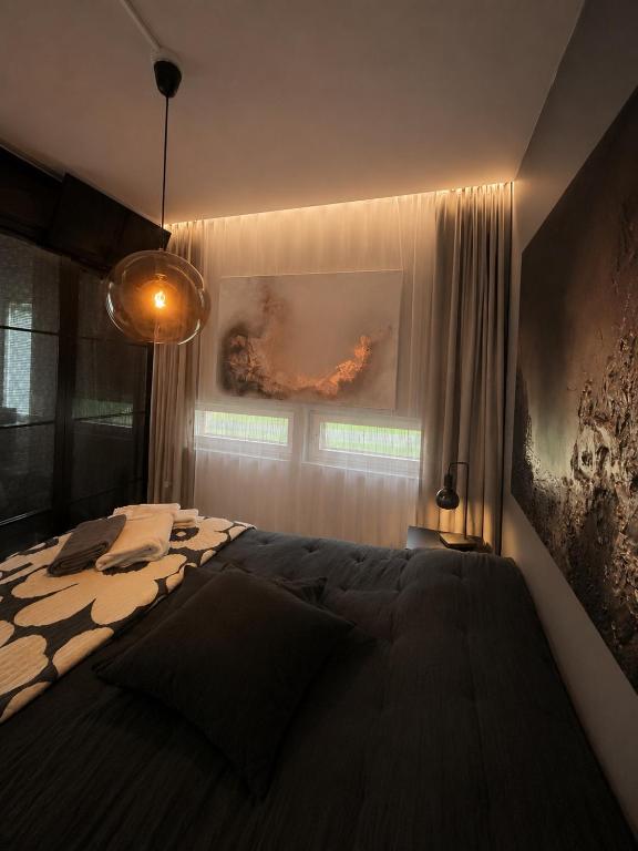 a bedroom with a large bed and a painting on the wall at Kraatterin Helmi Suite Resort Premium-Luxus 1107 in Lappajärvi