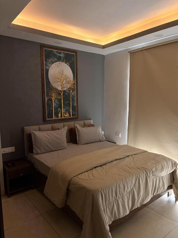 a bedroom with a large bed with a painting on the wall at Rabbit Stays apartment in Zirakpur