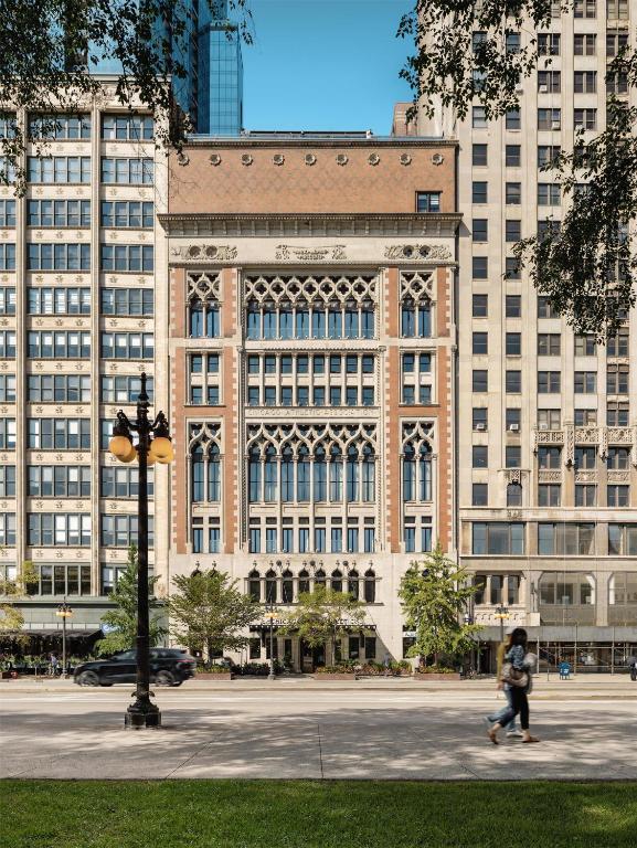 a large building with a person walking in front of it at Chicago Athletic Association, part of Hyatt in Chicago