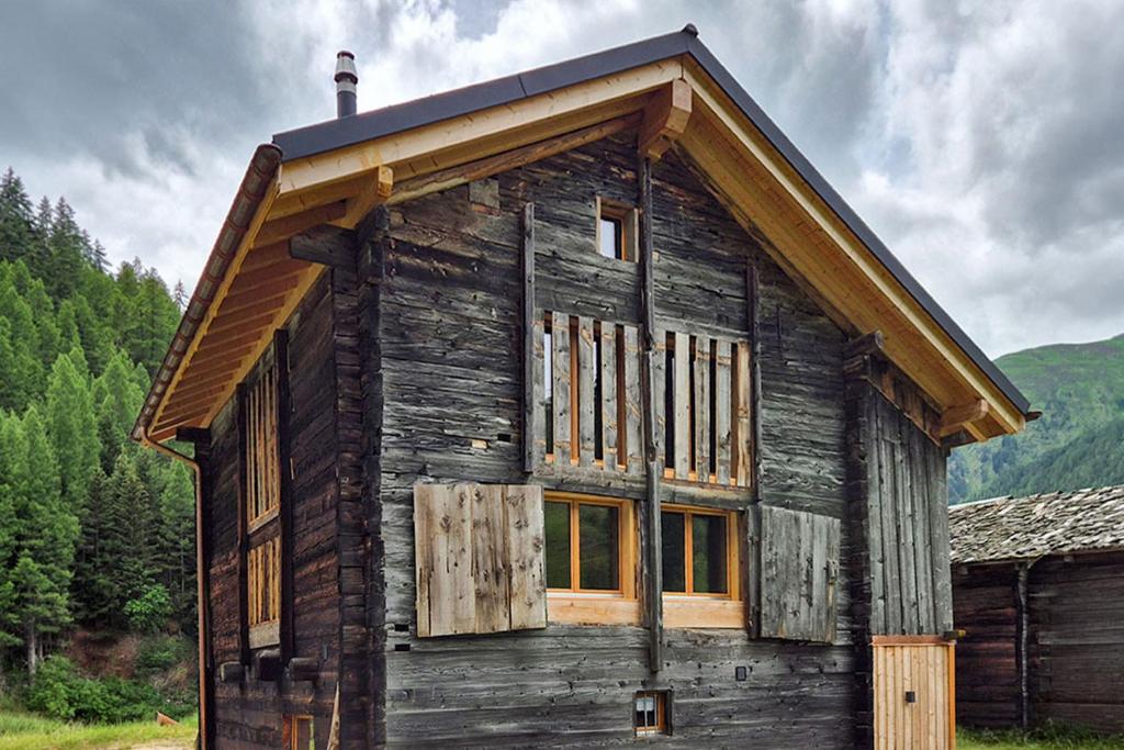 a small wooden cabin with a roof at Chalet Nufenen in Ulrichen