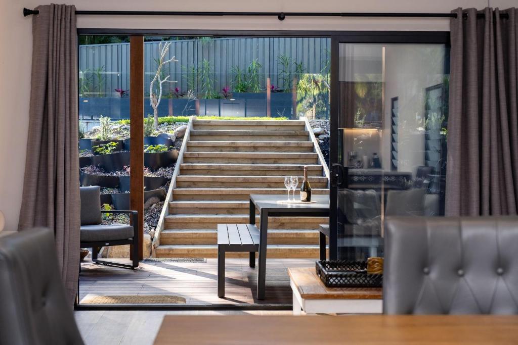 a room with stairs and a table and chairs at Valley Retreat in Smiths Lake