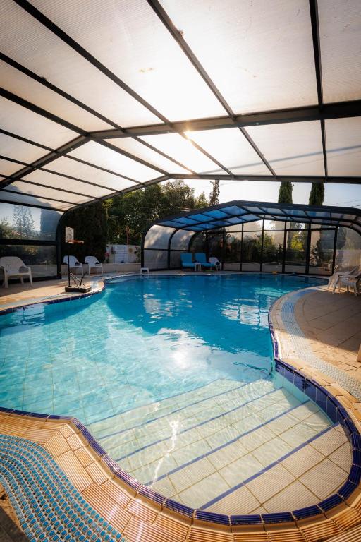 a large swimming pool with an open canopy at Arbel Guest House Shavit Family in Arbel