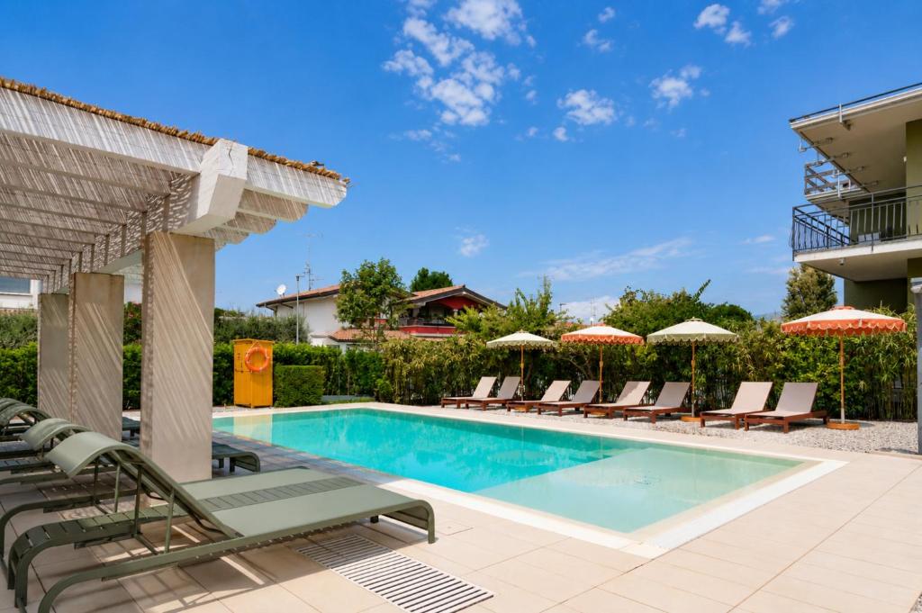 a swimming pool with lounge chairs and umbrellas at Best Western Hotel Arya in Sirmione