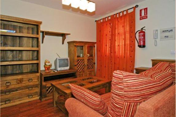 a living room with a couch and a tv at Apartamentos Rurales Les Mestes in Tazones