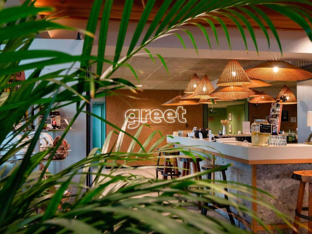 a restaurant with a bar with a first sign on the wall at Greet Hotel Colmar in Colmar