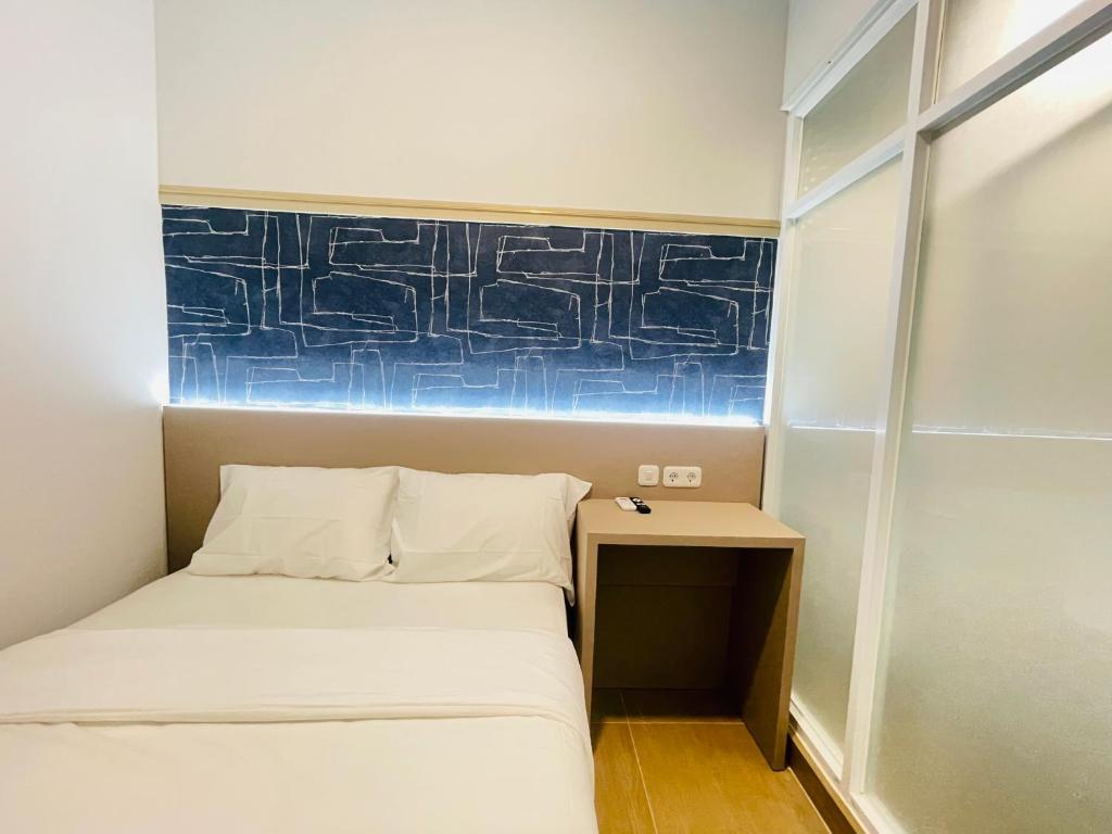 a small room with a bed and a table at Cana's Boarding Ciledug in Pasarjumahat-Kulon
