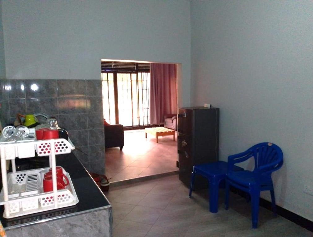 a kitchen with a counter and blue chairs in a room at Roadhouse in Jinja